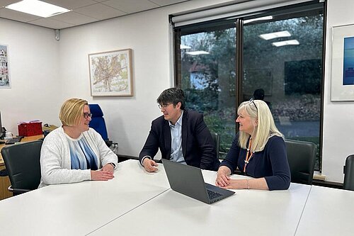 Zoe Franklin, Paul Follows and Julia McShane seated at a table, in discussion.